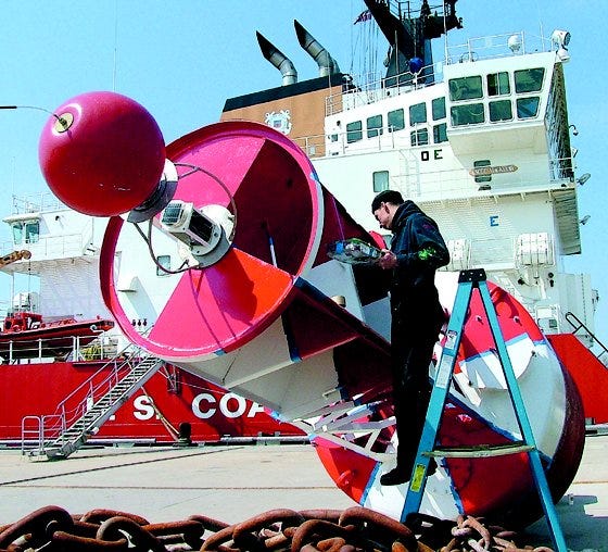 Sunny skies and warm temperatures made Wednesday a better day for painting buoys, agreed Seaman Colton Baker, 20, of Duncan, Okla. The huge marker is one of several soon to be commissioned during the next buoy-tending run of the U.S. Coast Guard cutter Mackinaw.