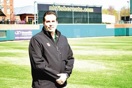 Rick Brenner, president and general manager of the New Hampshire Fisher Cats, dons a fleece jacket made for the team by EARTHTEC, a Portsmouth apparel company that makes clothing from recycled plastic bottles.