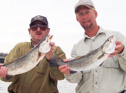 Captain Greg Schlumbrecht, right, and Goosie Guice show a couple of hefty specs caught at the Causeway bridge.