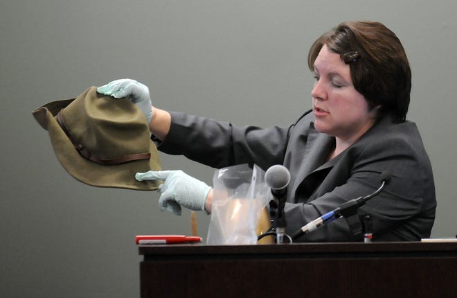 Sherri Menendez, a forensic chemist. holds a blood-spattered hat belonging to John Odgren.