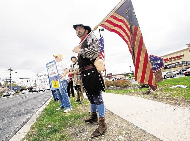 Charlie Redner of Kingston, in Revolutionary War garb, joins tea party members protesting the Obama administration's actions during a demonstration on Thursday along Route 9W near Kingston.