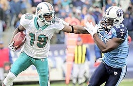 In this Dec. 20, 2009, file photo, Miami Dolphins wide receiver Ted Ginn Jr. (19) tries to fend off Tennessee Titans' Lavelle Hawkins (87) during the third quarter of an NFL game in Nashville, Tenn. The Dolphins traded Ginn on Friday to the San Francisco 49ers. (AP Photo/John Russell, File)