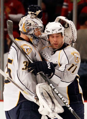 Nashville Predators goalie Pekka Rinne, left, celebrates with David Legwand after they defeated the Chicago Blackhawks 4-1 at Game 1 of their NHL Western Conference quarter-final hockey game in Chicago, Friday, April 16, 2010.