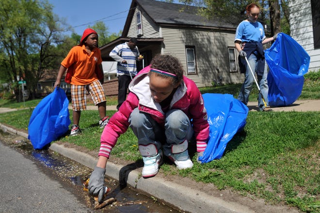 From left, Brian Duncan Jr., 8, Anthony Duncan, 21, Shaquoya Williams, 13, and Marie Miller, 19, pick up trash on Saturday morning near the intersection of John H. Gwynn Jr. Avenue and Sand Street in Peoria. According to a press release, approximately 1,200 volunteers were expected to participate in the Keep Peoria Beautiful Great American Cleanup day.