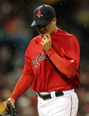 Red Sox relief pitcher Manny Delcarmen walks off the mound after giving up a two-run home run to Tampa Bay Rays' Pat Burrell during the 12th inning of their 3-1 loss in the conclusion of Friday night's rain-suspended game.