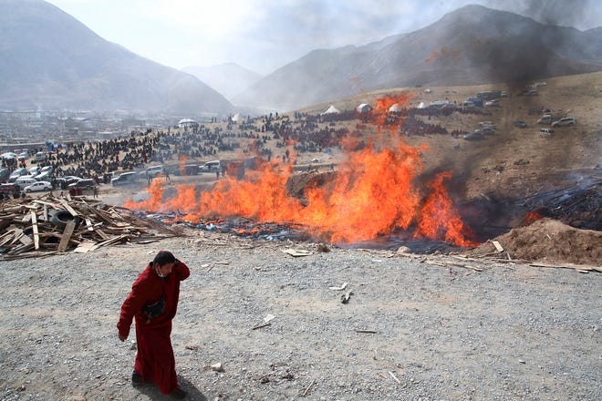 Hundreds of mourners gather on a hillside Saturday as the funeral pyres burn 
much of the day in Jiegu, China. The official death toll stands at 1,484.NEW 
YORK TIMES / DU BIN