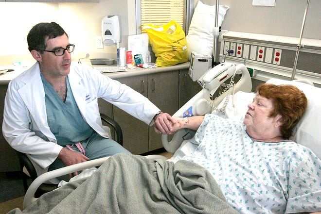 Neurosurgeon Paul Arnold sits down to visit patient Susan Davis in the Neuroscience Progressive Care unit at the University of Kansas Hospital in Kansas City, Kan.MCCLATCHY-TRIBUNE PHOTO