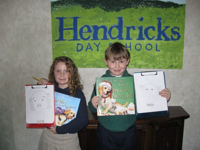 Two Mandarin second-graders, Mackenzie Barsh and William Joyce, show off their drawings of Marley, the famed yellow Lab.