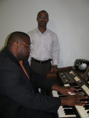 Reginald McKinney of Arlington (standing) operates a funeral home in Murray Hill. The Rev. Erich Jackson of the Westside is his administrative assistant and organist and preacher when needed.