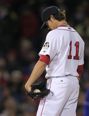 Red Sox pitcher Clay Buchholz hangs his head as he awaits the arrival of manager Terry Francona to remove him from the game during Boston's 3-0 loss to the Rangers.