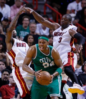 Boston Celtics forward Paul Pierce, center, looks for an opening past Miami Heat forward Dorell Wright, left, and guard Dwyane Wade, right, during the first half of Game 3 in the first round of their NBA basketball playoff series Friday, April 23, 2010, in Miami. (AP Photo/Wilfredo Lee)