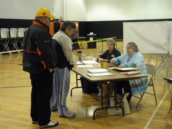 Two voters check in at the polls Tuesday at Oliver Ames High School.