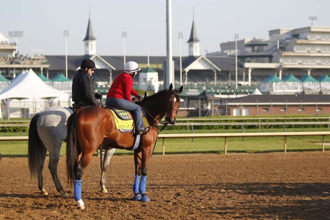 Exercise rider Dana Barnes (right), aboard favorite Lookin At Lucky, heads to the track during Derby preparation at Churchill Downs on Wednesday.