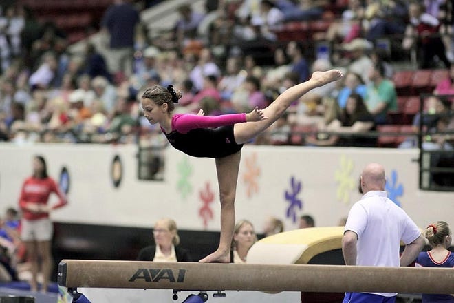 Grace McCullough of Island Gymnastics competes in the balance beam event at the AAU state championship last weekend in Lakeland. She won the event. By GARY MCCULLOUGH, Special to The Record