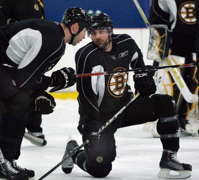 Boston Bruins captain Zdeno Chara, left, speaks with teammate Johnny Boychuk during practice in Wilmington, Mass. Thursday, April 29, 2010. The Bruins are preparing for their second-round NHL hockey playoff series against the Philadelphia Flyers which starts Saturday. (AP Photo/Elise Amendola)
