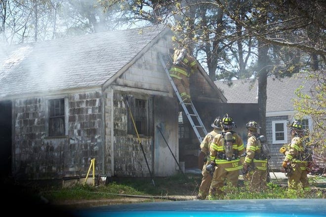 Firefighters battle a garage blaze in West Yarmouth yesterday afternoon.