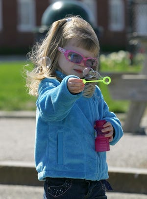 Sophia Boudreaux, 3, makes bubbles while visiting Nantasket Beach in Hull with her grandparents.