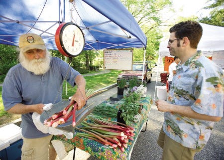 John Wakefield from Shagbark Farm in Rochester sells rhubarb to Jonathan Blakeslee, owner of White Heron Tea, during the opening day of the Exeter Farmers Market at Swasey Parkway in Exeter in 2009. The 2010 season kicks off on Thursday, May 6.