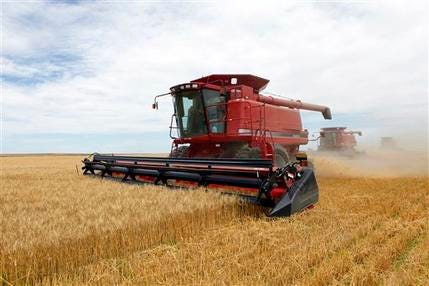 In this July 9, 2009, file photo three combines harvest the winter wheat on the Cooksey farm near Roggen, Colo.