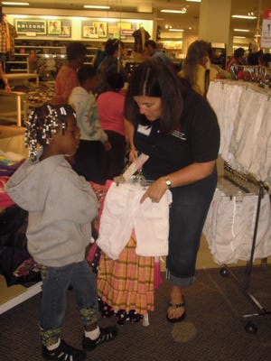 Andrea Rizzi of Riverside, president of the Junior League of Jacksonville, helps a young shopper.