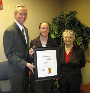 Edward J. Kelly, president of Milford Regional Medical Center, holds the award given to the VNA and Hospice of Greater Milford with Cindy Wilson, VNA quality improvement manager, center, and VNA Director Jean Maciarelli