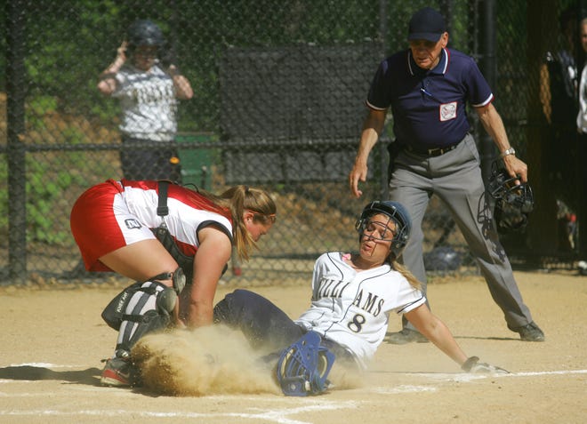 Archbishop Williams’ Laura McElroy scores in a cloud of dust against North Quincy catcher Katie Sheridan during the Bishops’ 11-4 non-league softball triumph Wednesday.