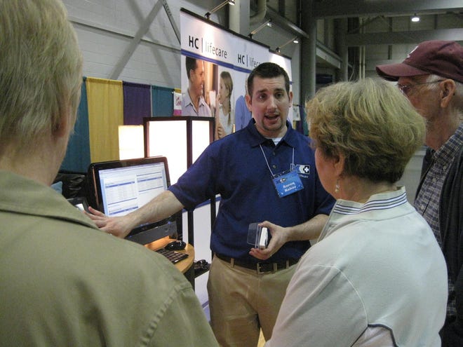 Aaron Koker, president of HC Life Care, explains the GrandCare Systems to attendees of the Boomers & Beyond Expo on Friday at the Kansas Expocentre.