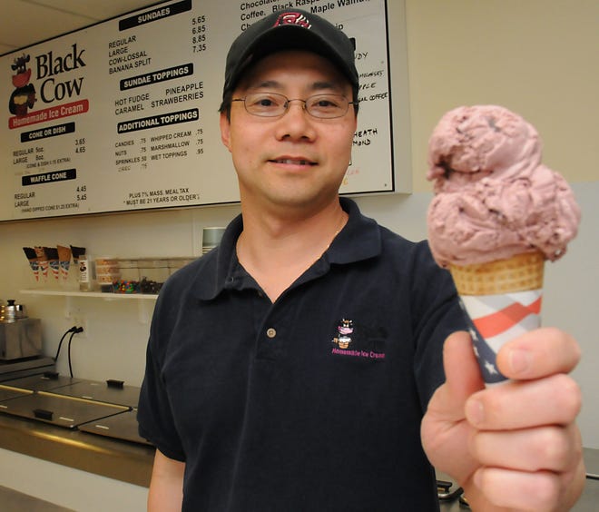 Tai Dong, owner of Black Cow Homemade Ice Cream in Natick, scoops some ice cream into a cone at his store.