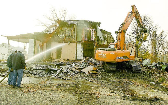 In this November 2009 photo, the former Linton Funeral Home on Youngstown’s near north side falls victim to the city’s demolition team.