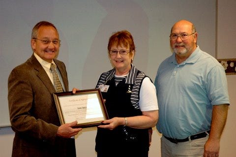 Branch-Hillsdale-St. Joseph Community Health Agency (BHSJCHA) Health Officer Steve Todd and board chairman Ron Olney present a plaque of appreciation to retiring Prevention Services Director Jeannie Sholly.