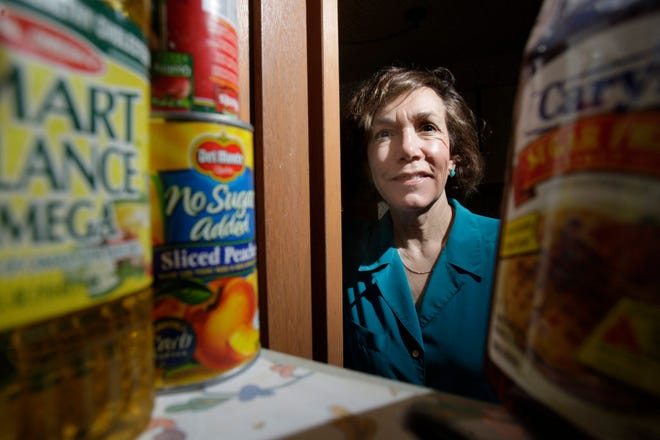 Marjorie Feldman poses for a photo surrounded by food she has stocked up on in her pantry, Friday, April 30, 2010, in Creve Coeur, Mo. (AP Photo/Jeff Roberson)