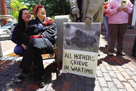 Macy Morse, second from left, 89, of Portsmouth, braves the chilly day to join others at a Mother’s Day peace vigil held Sunday in downtown Portsmouth.