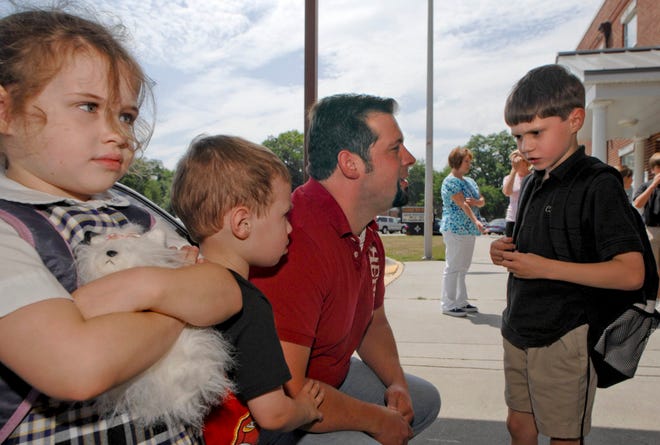 Tim Blake talks with his son Gabriel, 6, as he waits with his daughter Abigail, 5, and son Malcolm, 3, for his oldest son Grayson, 8, to get out of class Monday at Calvary Day School. Richard Burkhart/Savannah Morning News