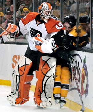 Philadelphia Flyers goalie Michael Leighton checks Boston Bruins left wing Steve Begin into the boards during the second period of Game 5.