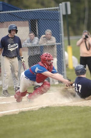 Winnacunnet High School catcher John Mills attempts to put the tag on Exeter’s Tim Doucette in the first inning of Friday afternoon’s game between the two Class L rivals in Exeter. Doucette was called safe after the ball popped free.

Ken Stejbach photo