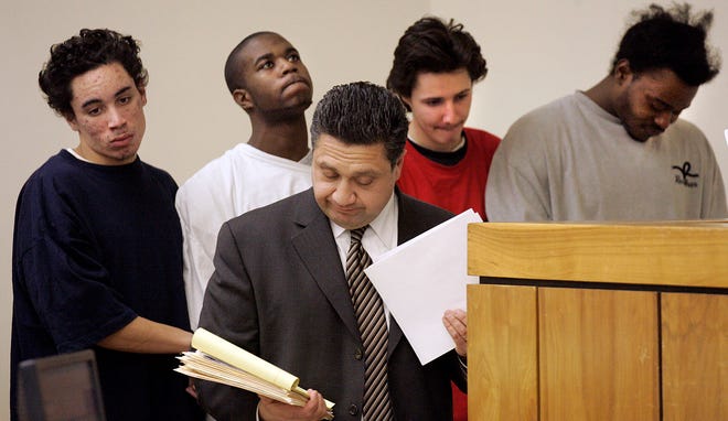 Suspects in a school shooting case outside North Quincy High School were arraigned in Quincy District Court on Thursday. From left, David White, Leon Perry, Christopher Ochs and Maurice Perry stand in the dock behind lawyer Raffi Yessayan, who represents Ochs, in front of Judge Diane Moriarty on the matter of bail. Each defendant had his own lawyer.