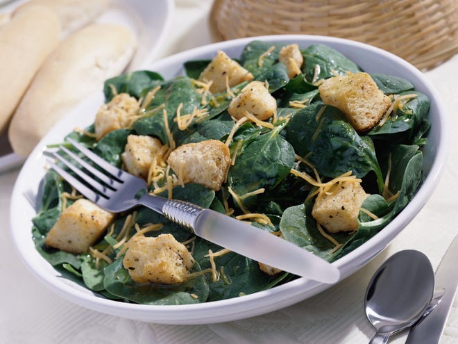 Slight cooking in the bowl of wilted salad releases the sweet, tangy flavors of spring spinach. Add garlic croutons and you have a meal.