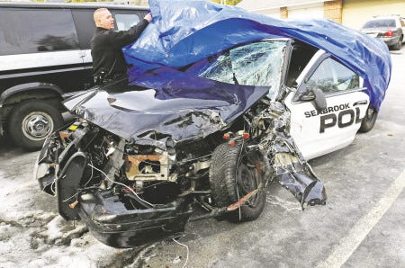 Seabrook police officer John Mounsey uncovers a cruiser involved in an accident during a high-speed chase in February.