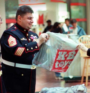 Michael P. Frisoli, in Marine regalia, accepts a toy during a toy drive in 2001 in Shrewsbury.