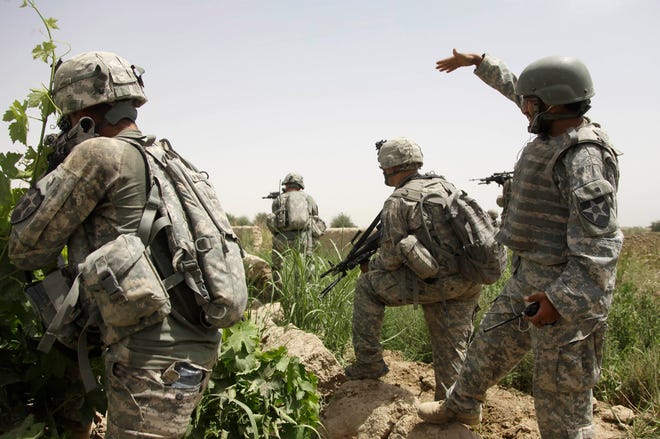 In this May 8, 2010 file photo, an Afghan interpreter, right, working on a patrol with of 2nd Platoon, Alpha Company, 2nd Battalion, 1st Infantry Regiment of the 5th Stryker Brigade, calls over some local teenagers who were seen moving suspiciously in a tree line in Afghanistan's Kandahar province.
