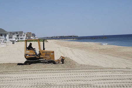 Seabrook DPW employee Asa Knowles IV works to smooth out the mounds of sand at Seabrook Beach in preparation for the upcoming beach season.
