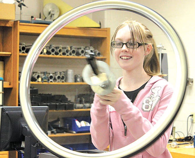 Darian Fann, seventh-grade student at Waynesboro Area Middle School, uses a spinning wheel to change her direction on a pedestal during a Phun with Physics workshop at Penn State Mont Alto Monday. Seventh-graders also are visiting the campus today and tomorrow to take part in three hands-on sessions as part of an introduction to college program.