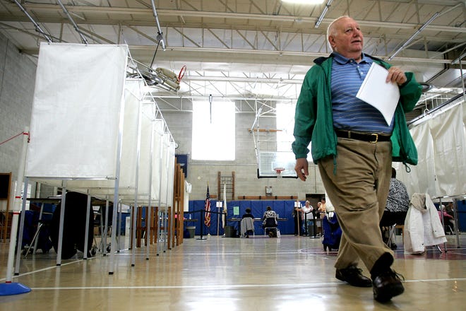 Joe Cannistraro of Medway walks through the Medway Middle School's gymnasium to cast his ballot for water/sewer commissioner during Medway's annual town election Tuesday.