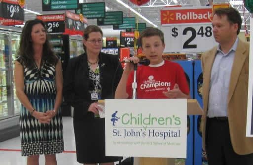 Jack Londrigan (middle) speaks after being named Children's Middle Network Champion for Illinois at the Walmart Supercenter, 2760 N. Dirksen Parkway, on Tuesday. Standing behind him are, from left, his mother, Betsy; Susan Farr, a Walmart marketing manager; and his father, Tom.