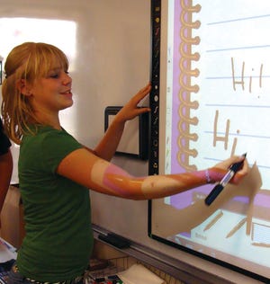 Eighth-grader Sandy Baker demonstrates how to use the stylus of the interactive white board.