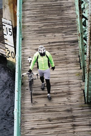 A bicyclist walks over the Memorial Bridge in Portsmouth recently.