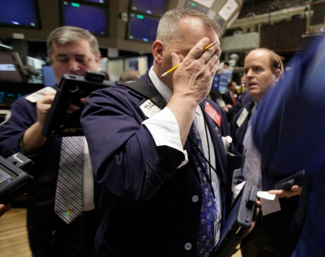 Trader Albert Young, center, works on the floor of the New York Stock Exchange Friday, May 21, 2010. (AP Photo/Richard Drew)