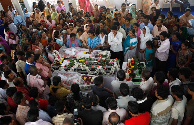 Relatives grieve next to the bodies of victims who died in an Air India Express plane crash in Mangalore, India.