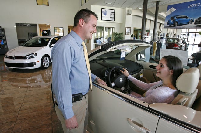 Ian Franz, Volkswagen brand manager at Kempthorn Auto Mall, shows a convertible to Ruth Pearce