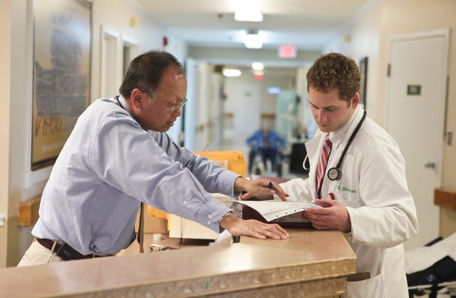 A doctor shows a medical student paperwork on a patient at a Bedford, Ky., nursing home. The eight local practitioners who opted out of Medicare in recent years might be the tip of the iceberg. Lurking beneath the surface may be dozens more doctors. If they're not already limiting their numbers of Medicare patients, they're probably thinking about it, local and state experts said.